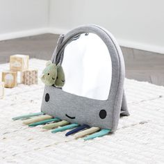 a gray whale shaped mirror sitting on top of a white rug next to wooden blocks