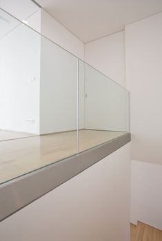 an empty room with white walls and wood flooring is seen through the glass wall