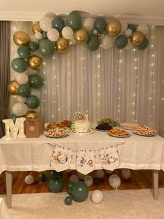 a table topped with lots of food and balloons