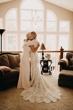 two brides hugging each other in the living room