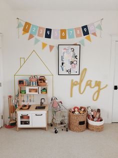 a playroom with toys and decorations on the wall in front of a door that says play