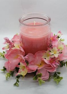 a candle with pink flowers around it