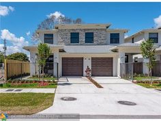 a two story house with garages in the front yard and landscaping on the side