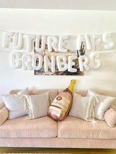 a bottle of champagne sitting on top of a couch in front of a sign that says future airs gronder