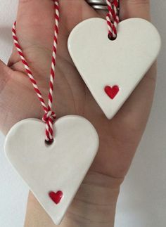 two ceramic heart ornaments with candy canes in their hands