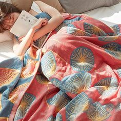 a woman laying in bed reading a book