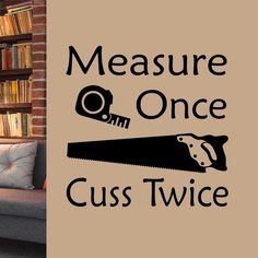 there is a sign that says measure once cuss twice on the wall next to a couch