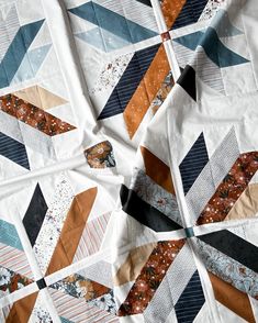 a close up view of a quilt made with different colors and designs on it's surface