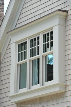 an image of a window on the side of a house that is white and brown