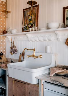 a white sink sitting under a window next to a wooden cabinet and counter top in a kitchen