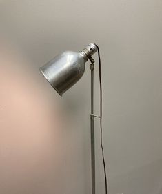 a lamp that is sitting on top of a wooden table next to a white wall