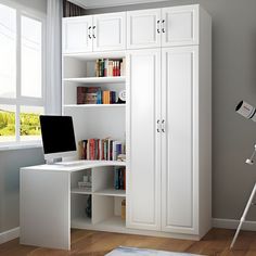 a white computer desk sitting under a window next to a book shelf filled with books