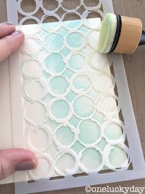 someone is using a paint roller to decorate a paper doily with circles on it