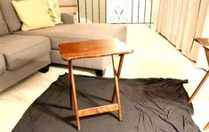 a table sitting on top of a black cloth covered floor next to a gray couch