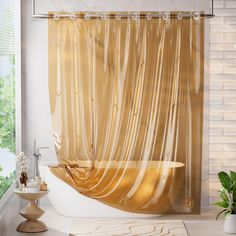 a bathroom with a bathtub, shower curtain and potted plant on the counter