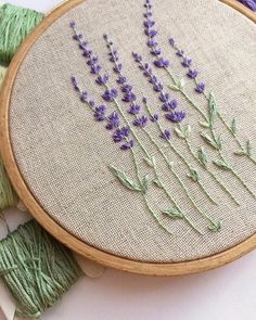 lavender flowers are stitched together in an embroidery hoop