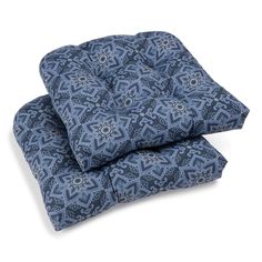 two blue cushions sitting next to each other on top of a white surface with an intricate pattern