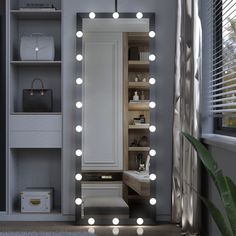 a large mirror with lights on it in a room next to a shelf and window