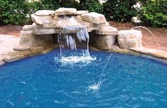 a pool with a waterfall and chairs around it