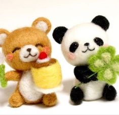 two small stuffed animals are holding flowers