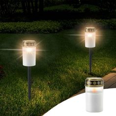 three solar powered lights in the grass