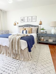 a bedroom with a bed, nightstands and pictures hanging on the wall above it