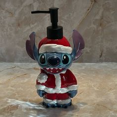 a glass toothbrush holder in the shape of a cartoon character wearing a santa claus outfit