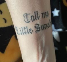 someone with a tattoo on their arm that says, tell me little sunshine