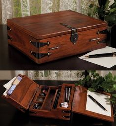 an open wooden briefcase sitting on top of a table next to a pen and paper