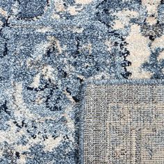 an area rug with blue and white designs on the carpet, close up view photo