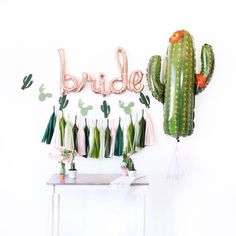 a cactus themed bridal party with balloons and tassels on the side table