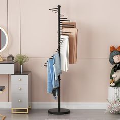 a clothes rack in the corner of a room next to a dresser and mirror with clothing hanging on it