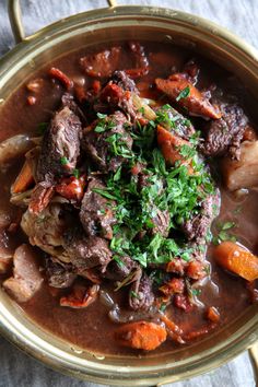 a bowl filled with meat and vegetables on top of a table