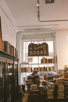 a room filled with lots of books and a sign hanging from the ceiling above it