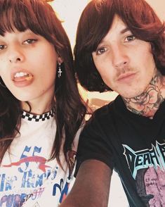 a man and woman with tattoos posing for the camera