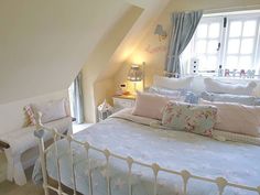 a white bed sitting under a window in a bedroom