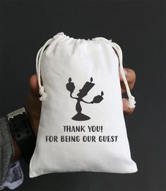 a person holding a white bag with the words thank you for being our guest on it