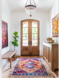 an entryway with wooden doors and rugs on the floor