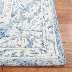 a blue and white area rug on a wooden floor with hard wood floors in the background