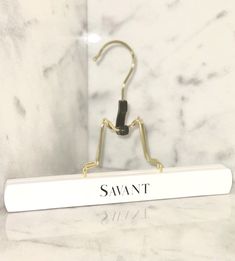 a white marble counter top with a sign that says saunt on it and a pair of scissors in the middle