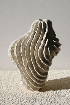 a white vase sitting on top of a table next to a wall and carpeted floor