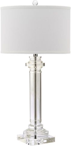 a table lamp with a white shade on it and a light in front of the lamp