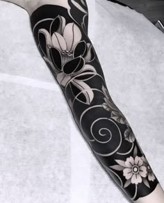 a black and white flower tattoo on the arm