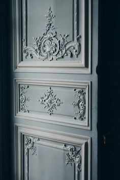 an old door with ornate carvings on the front and side panels, painted in white