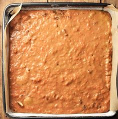 a baking pan filled with batter on top of a wooden table