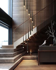 the stairs in this modern house are made of wood and metal, with lights hanging from them