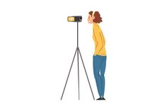 a woman is standing in front of a tripod and taking pictures with her camera