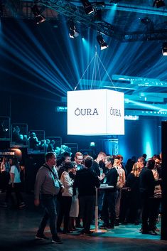 a group of people standing in front of a sign that says oura on it