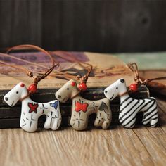 three ceramic dogs are sitting on a table next to an old book and some string