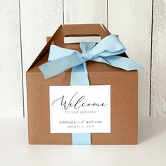 a brown box with a blue ribbon and welcome sign